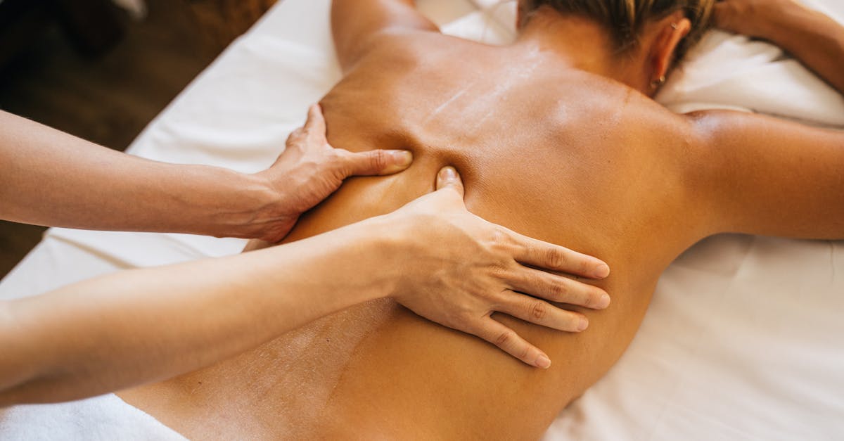 Close-up of a relaxing massage therapy session at a spa with focus on back and hands.